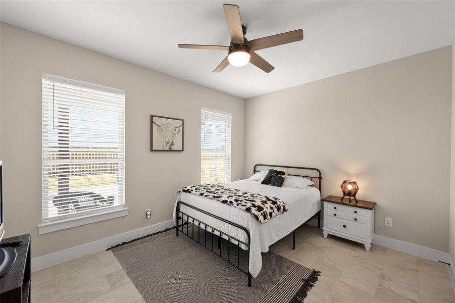 Tiled bedroom featuring ceiling fan