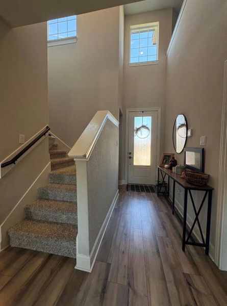 Foyer with double-height ceiling and a wood-finish flooring