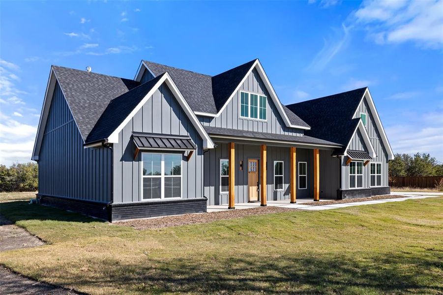 Modern farmhouse style home with a porch and a front lawn