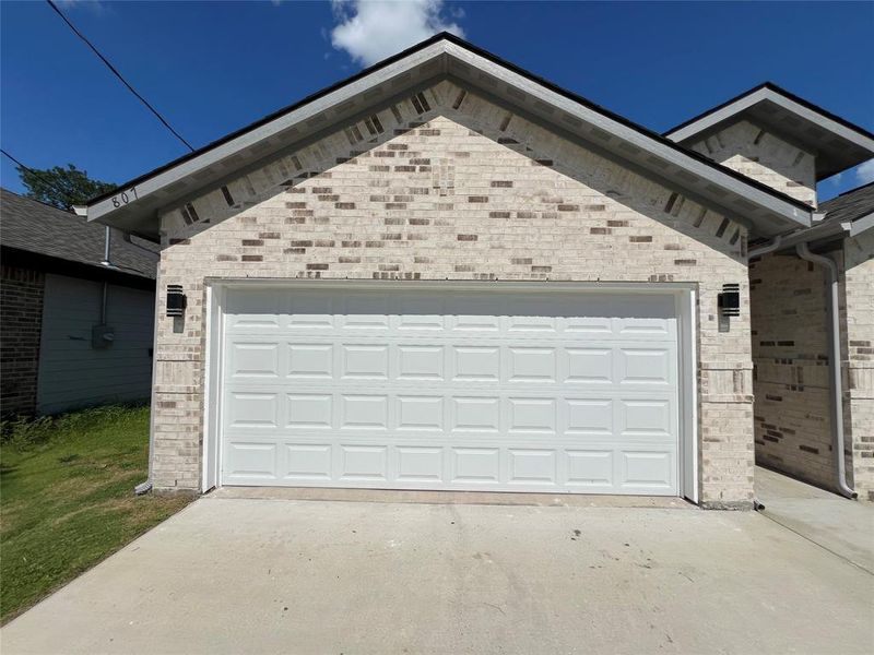 View of home's exterior featuring concrete driveway, an attached garage, and brick siding View of home's exterior featuring concrete driveway, an attached garage, and brick siding