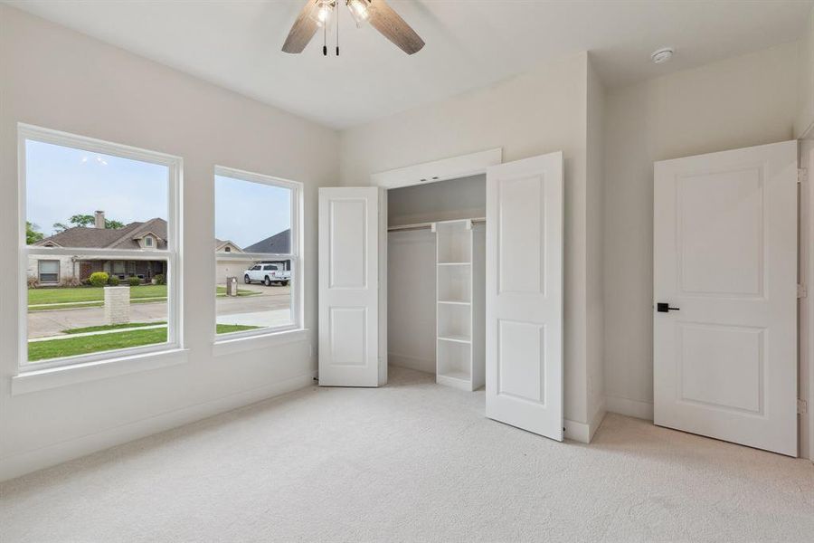 Unfurnished bedroom featuring baseboards, a closet, ceiling fan, and carpet flooring