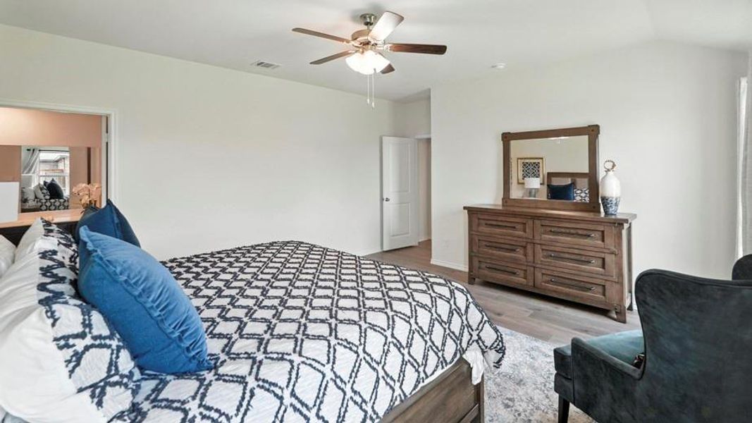 Bedroom with light wood-type flooring, ceiling fan, and vaulted ceiling Bedroom with light wood-type flooring, ceiling fan, and vaulted ceiling