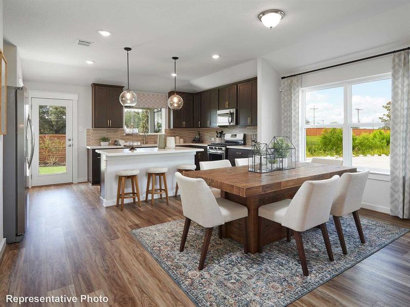The kitchen features dark wood cabinetry, stainless steel appliances, and a tiled backsplash