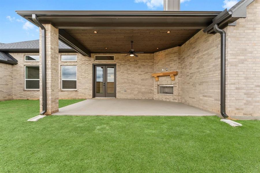 Covered Rear Patio with Wood Burning Fireplace, Ceiling Detail, and Fan