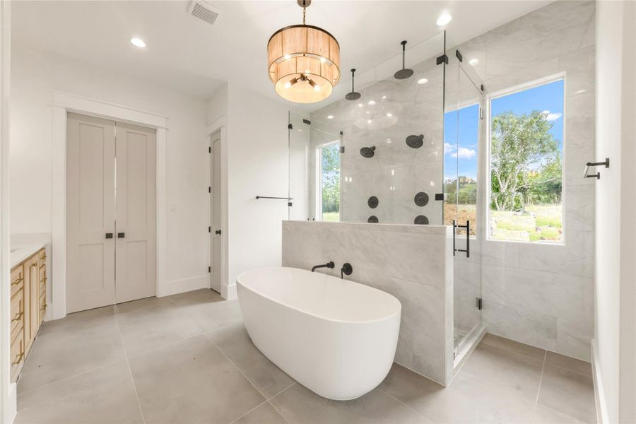 Bathroom with a shower stall, a freestanding bath, vanity, recessed lighting, and light tile patterned floors