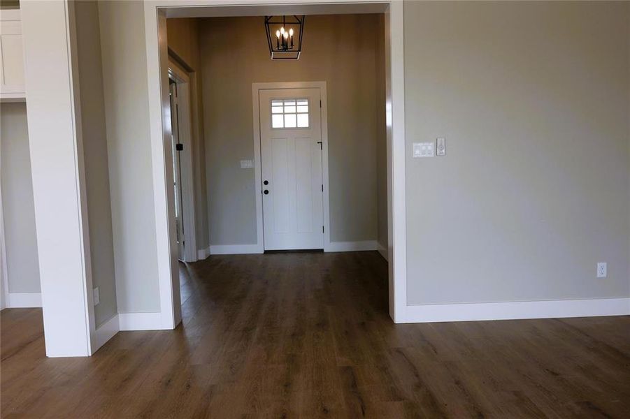 Entryway featuring dark hardwood / wood-style floors and a chandelier