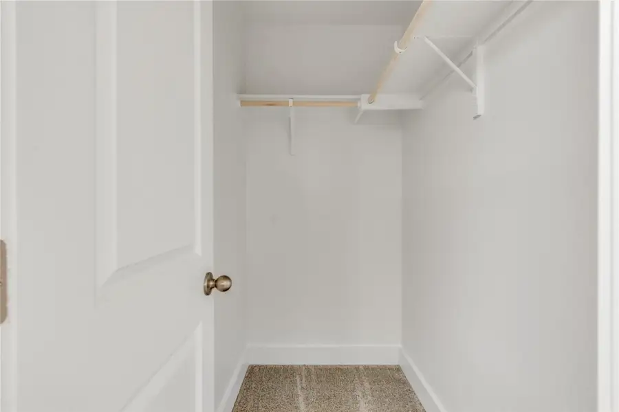 A well-organized closet offers ample storage with sturdy shelving and hanging rods.