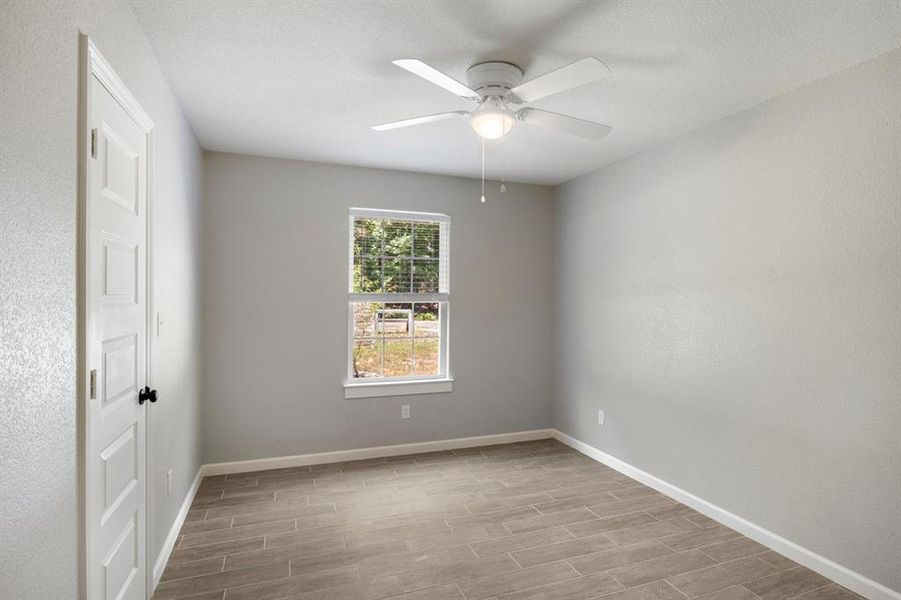 Unfurnished room with wood tiled floors and a ceiling fan Unfurnished room with wood tiled floors and a ceiling fan