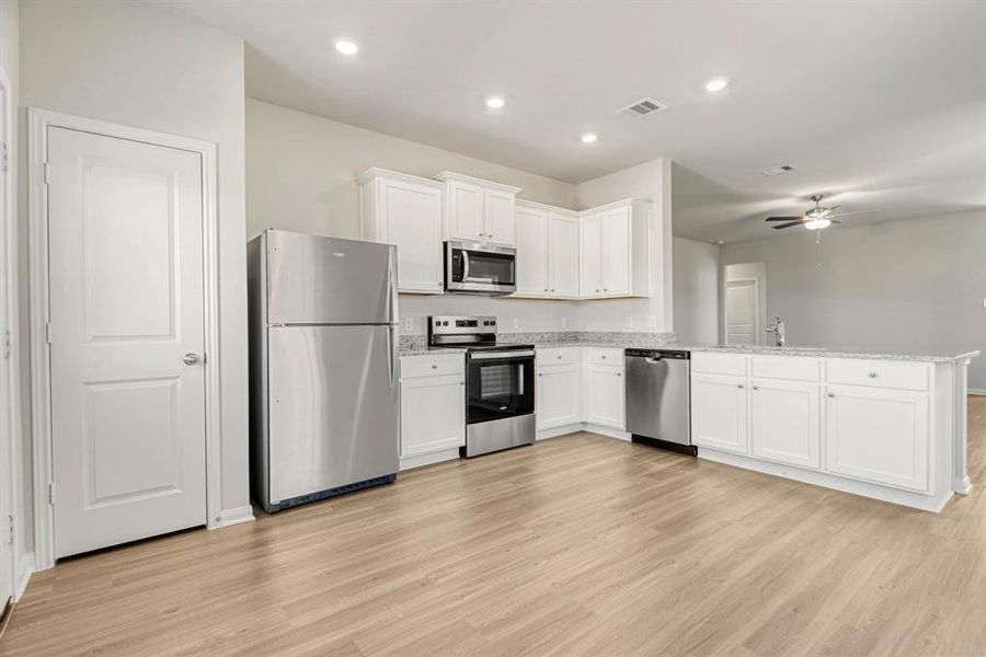 The kitchen is upgraded with Whirlpool appliances and granite countertops.