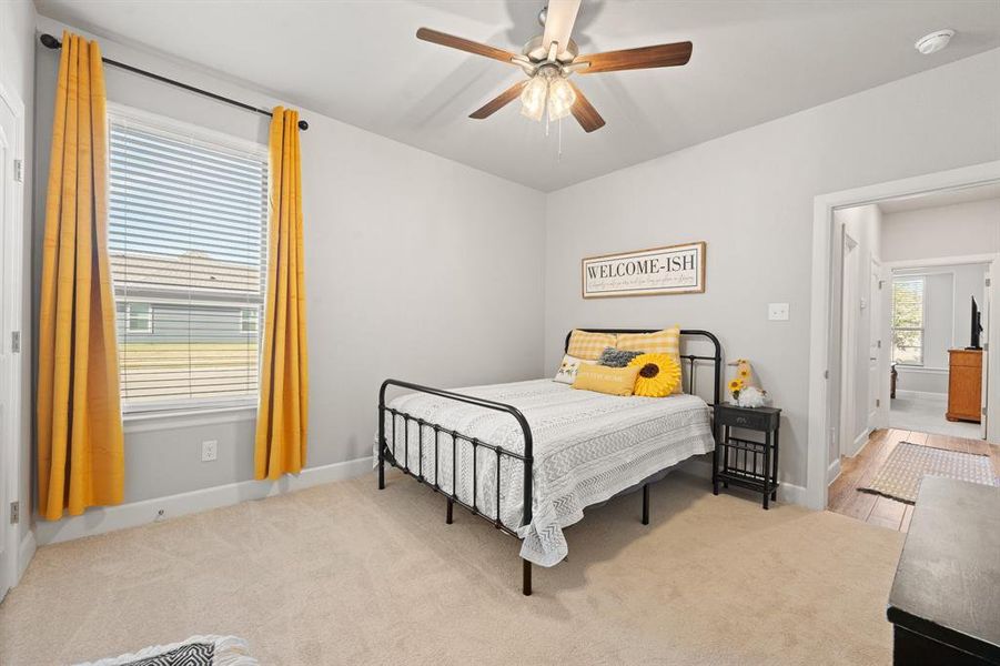 Bedroom with a ceiling fan and light carpet