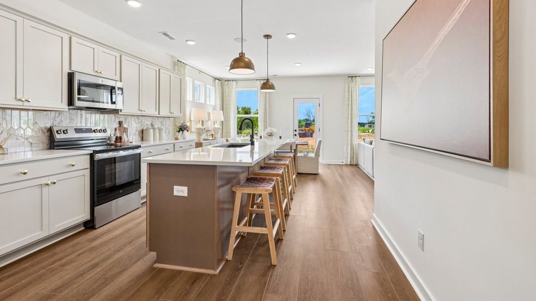 Kitchen with tile backsplash, pendant lighting, and quartz countertops Kitchen with tile backsplash, pendant lighting, and quartz countertops