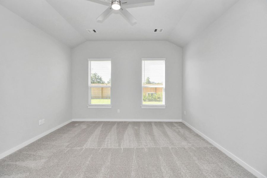 Escape to tranquility in this spacious primary room, adorned with plush carpeting and bathed in the soothing hues of warm paint colors, creating a cozy retreat for relaxation. Sample photo of completed home with similar floor plan. Actual colors and selections may vary.
