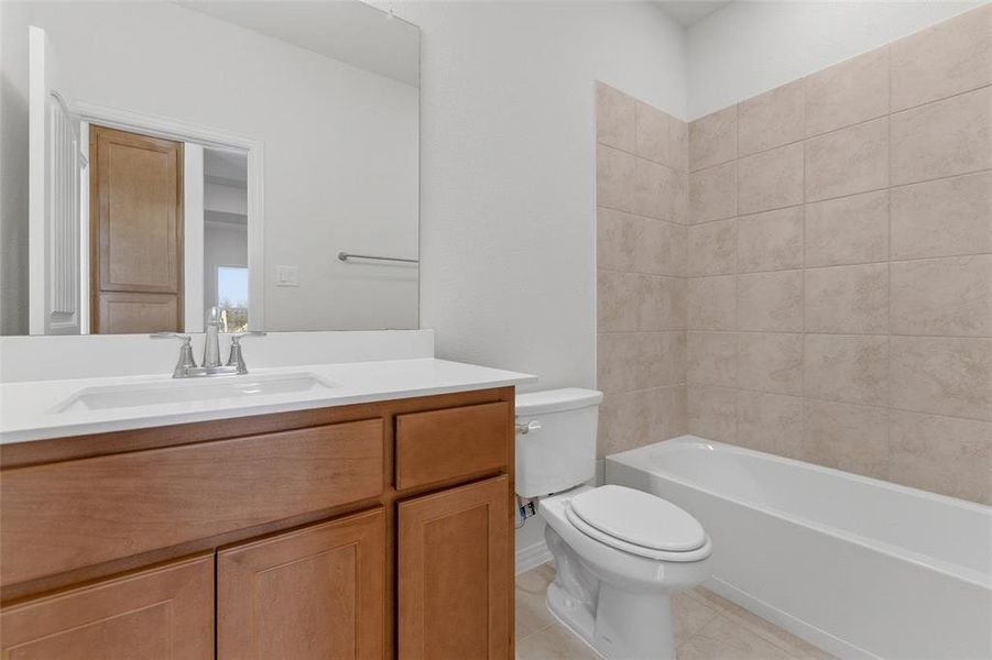 Bathroom with vanity, shower / bathtub combination, and light tile patterned floors