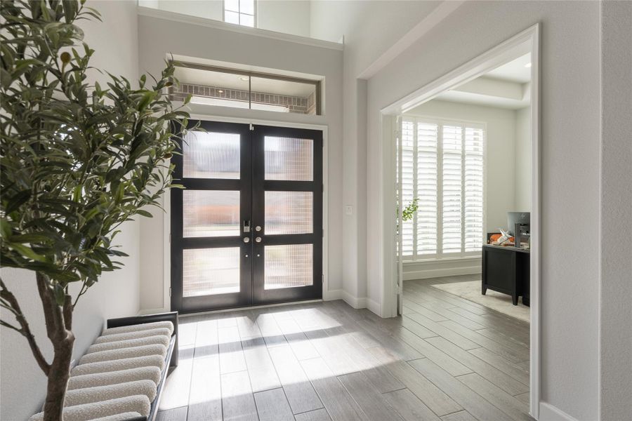 Bright, welcoming entryway featuring a modern double door with frosted glass panels. Bright, welcoming entryway featuring a modern double door with frosted glass panels.