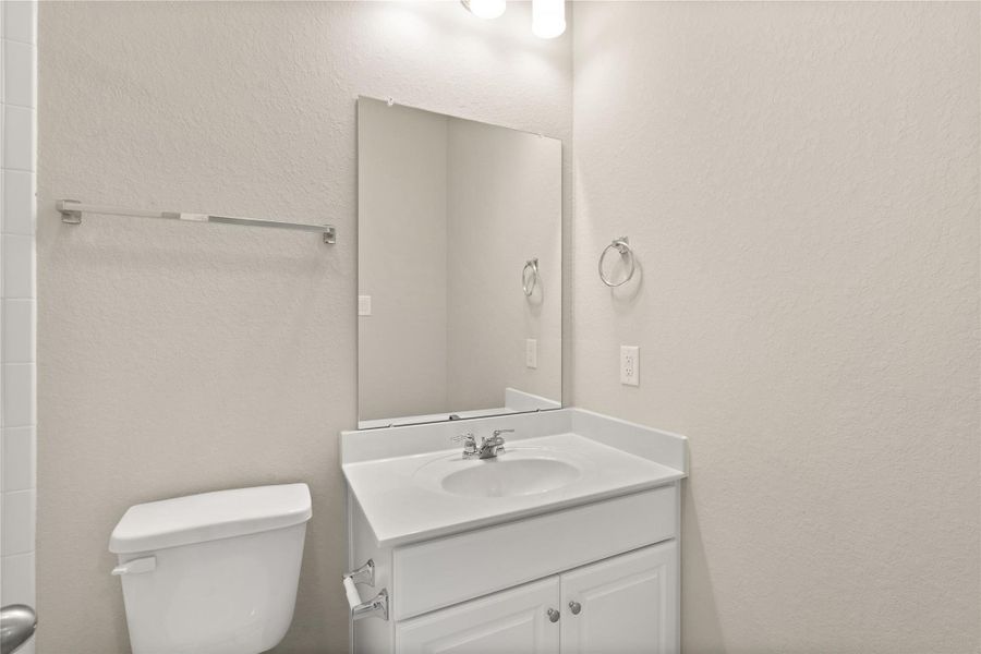 This secondary bathroom features tile flooring, white cabinetry and light counter tops, and shower-tub combo.