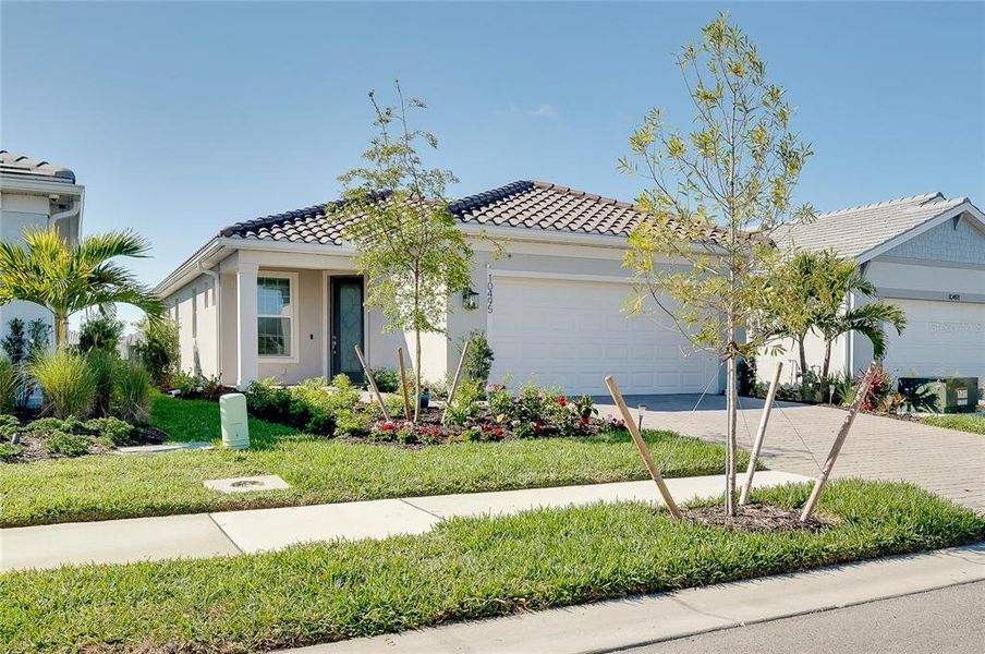 Front exterior of a new home in BeachWalk by Manasota Key, Englewood, FL, highlighting curb appeal (Image 26).