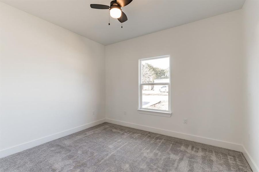 Carpeted spare room with ceiling fan