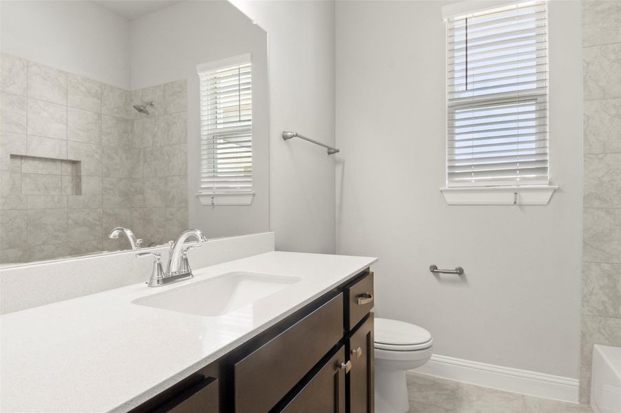 Bathroom featuring vanity, marble look tile flooring, and bathtub / shower combination