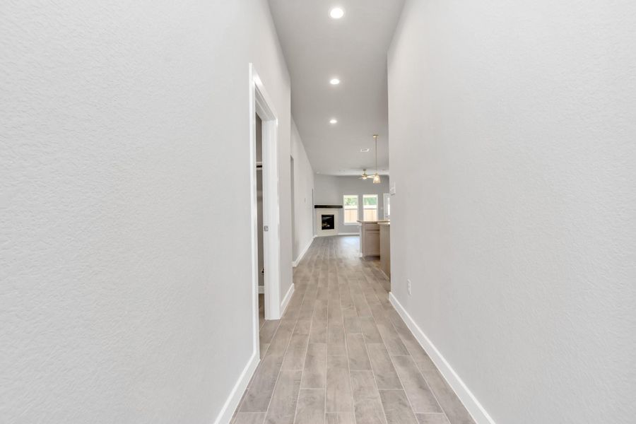 The grand entrance welcomes you with tile floors, oversized baseboards, and recessed lighting, setting the stage for a luxurious journey. Follow the Long Walkway to discover the open-concept kitchen and family room, where elegance meets comfort seamlessly. Sample photo of completed plan. As-built color and selections may vary. The grand entrance welcomes you with tile floors, oversized baseboards, and recessed lighting, setting the stage for a luxurious journey. Follow the Long Walkway to discover the open-concept kitchen and family room, where elegance meets comfort seamlessly. Sample photo of completed plan. As-built color and selections may vary.