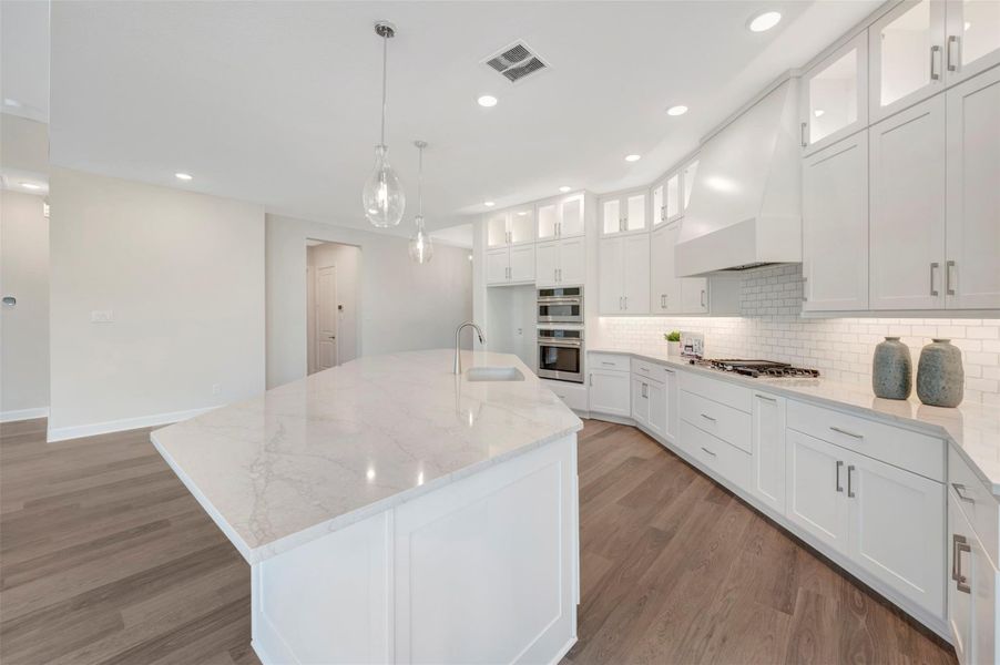 Updraft vent hood, 5 burner gas cooktop, subway tile backsplash, self close drawers/doors, quartz counters & so much more!