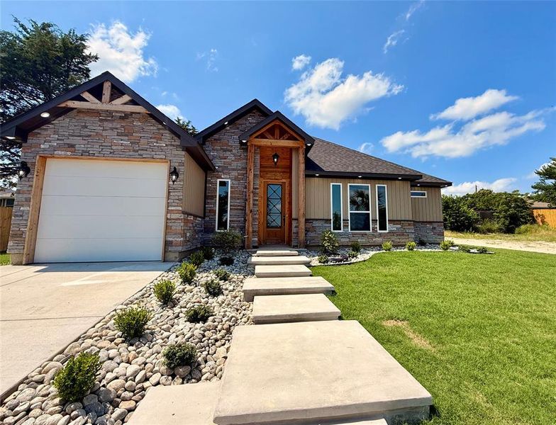 View of front of house with a front lawn, a garage, concrete driveway, and stone siding View of front of house with a front lawn, a garage, concrete driveway, and stone siding