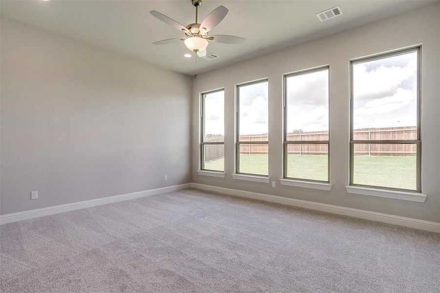 Carpeted empty room with ceiling fan