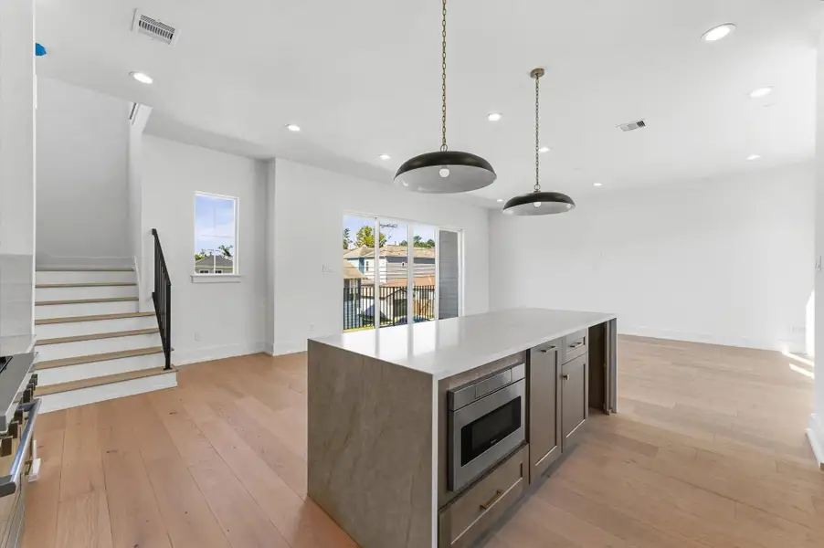 Kitchen features stainless steel Bosch appliances including 36' range, quartz countertops, and Venetian plaster hood range.