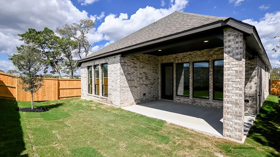 Back of property featuring brick siding, a patio, and a shingled roof Back of property featuring brick siding, a patio, and a shingled roof