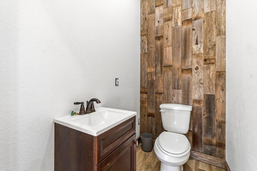 Half bath with wood accent wall perfect for guest use.