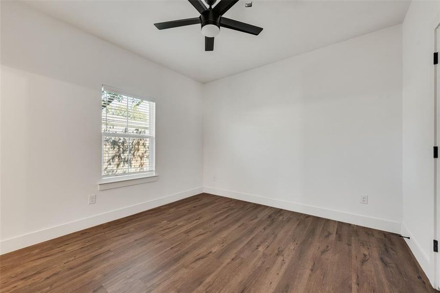 Empty room with dark wood-style floors and ceiling fan Empty room with dark wood-style floors and ceiling fan