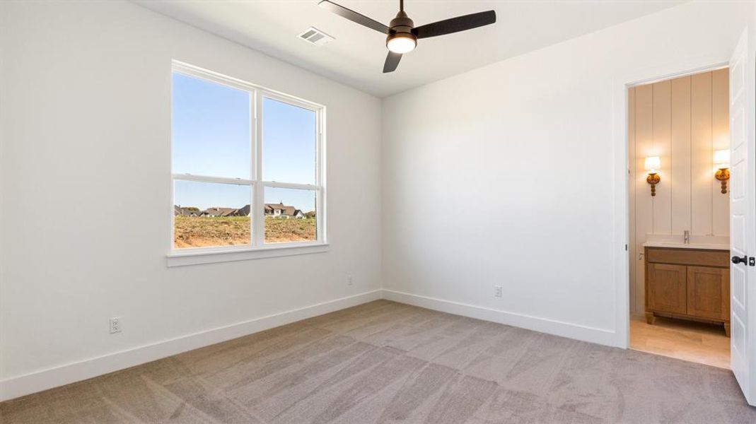 Carpeted spare room featuring ceiling fan