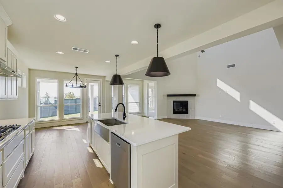 Kitchen with white cabinets, hanging light fixtures, dark wood-style floors, appliances with stainless steel finishes, and recessed lighting