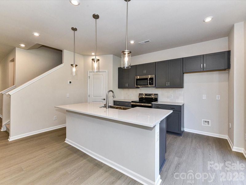 Kitchen with Rich grey cabinets and white countertops