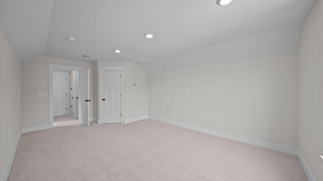 Elegant bedroom retreat featuring soft carpeting and a thoughtfully designed walk-in closet