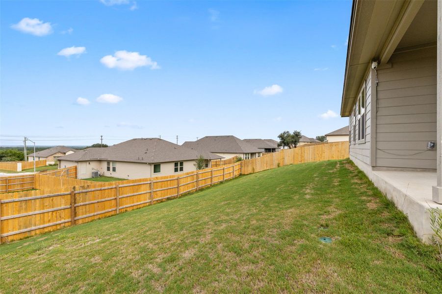 Fenced backyard with a residential view and a patio