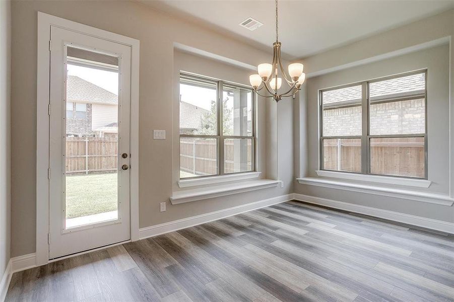 Unfurnished dining area with an inviting chandelier and wood-type flooring