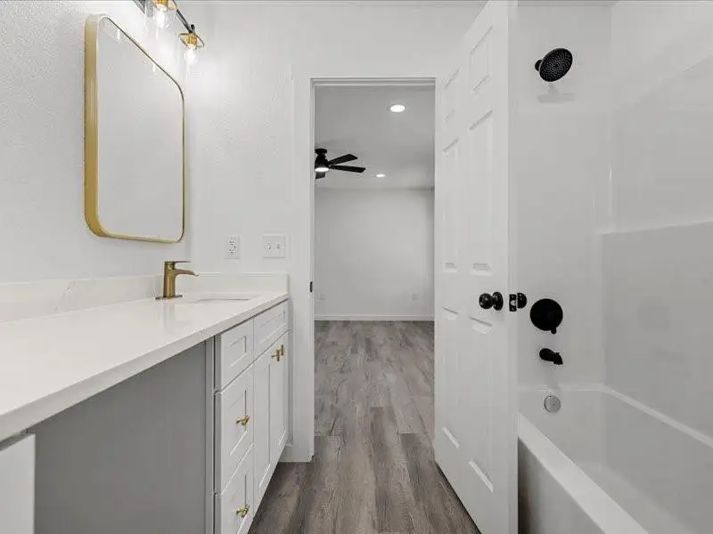 Bathroom featuring washtub / shower combination, dark wood-style floors, vanity, and recessed lighting