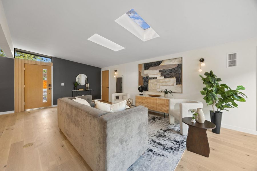 An inviting living area with warm wood flooring and natural light from skylights An inviting living area with warm wood flooring and natural light from skylights