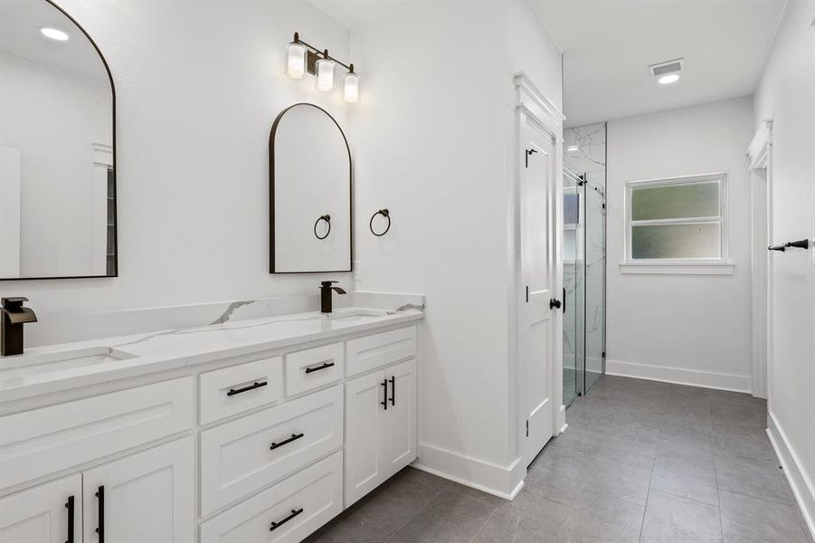 Bathroom with recessed lighting, double vanity, a stall shower, and dark tile patterned flooring
