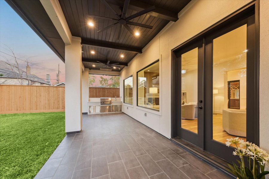 Designed for year round outdoor living, the covered patio offers generous space for dining and lounging beneath a paneled ceiling with recessed lighting and ceiling fan. Built in grill and prep area keep entertaining effortless, while wide doors and windows maintain a seamless connection back to the main living spaces. Designed for year round outdoor living, the covered patio offers generous space for dining and lounging beneath a paneled ceiling with recessed lighting and ceiling fan. Built in grill and prep area keep entertaining effortless, while wide doors and windows maintain a seamless connection back to the main living spaces.