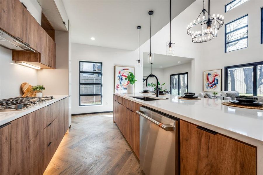 Kitchen featuring modern cabinets, stainless steel appliances, brown cabinets, hanging light fixtures, and recessed lighting Kitchen featuring modern cabinets, stainless steel appliances, brown cabinets, hanging light fixtures, and recessed lighting
