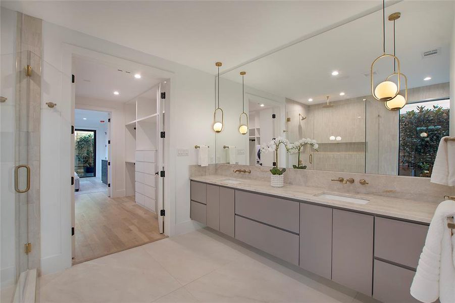 Bathroom with tile patterned floors, vanity, and a shower with door