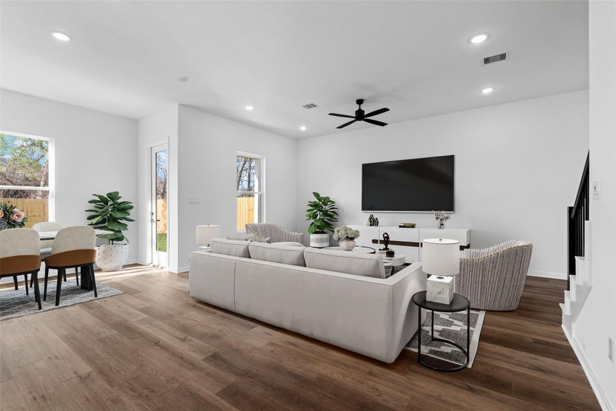 Virtually staged living room showcasing an open and inviting layout, with modern seating and natural light flowing into the kitchen