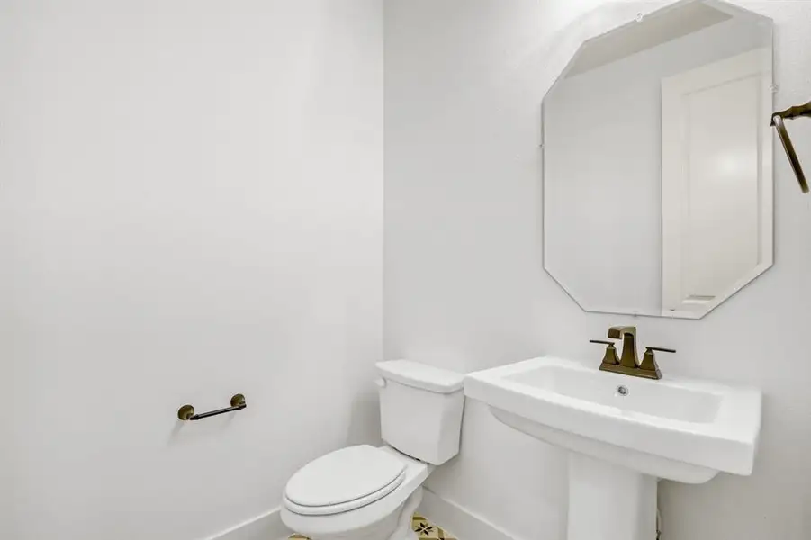 Half bathroom with toilet and baseboards