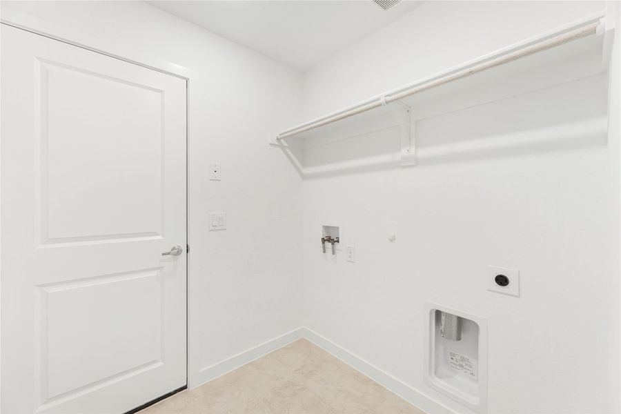 Laundry room with white walls, wall-mounted shelf, washer hookups, and dryer vent connection