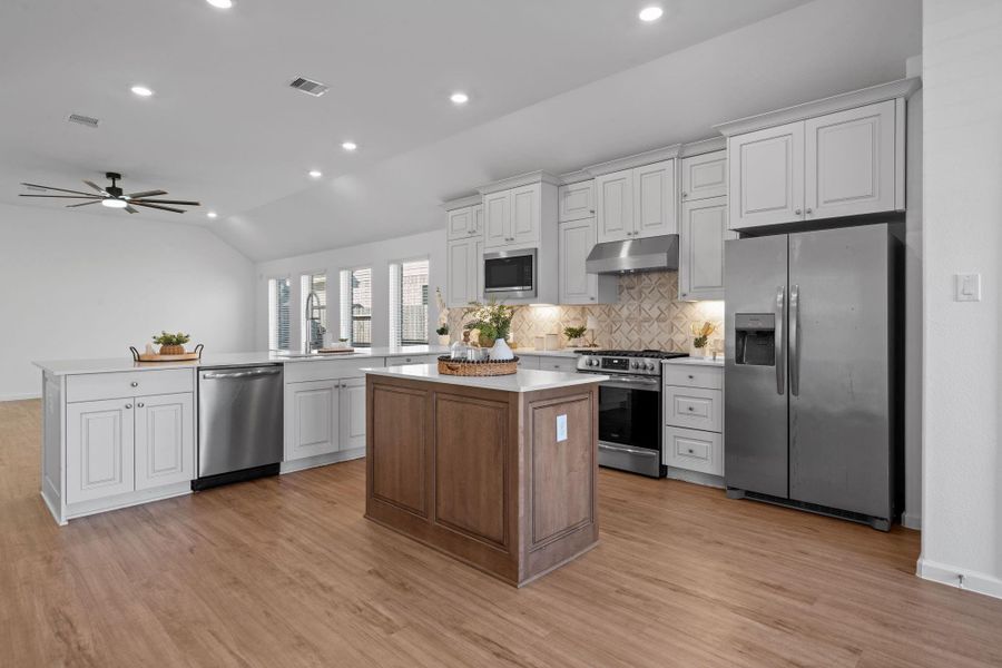 With its crisp white cabinetry, sleek stainless steel appliances, and gorgeous statement backsplash, it feels both modern and timeless.