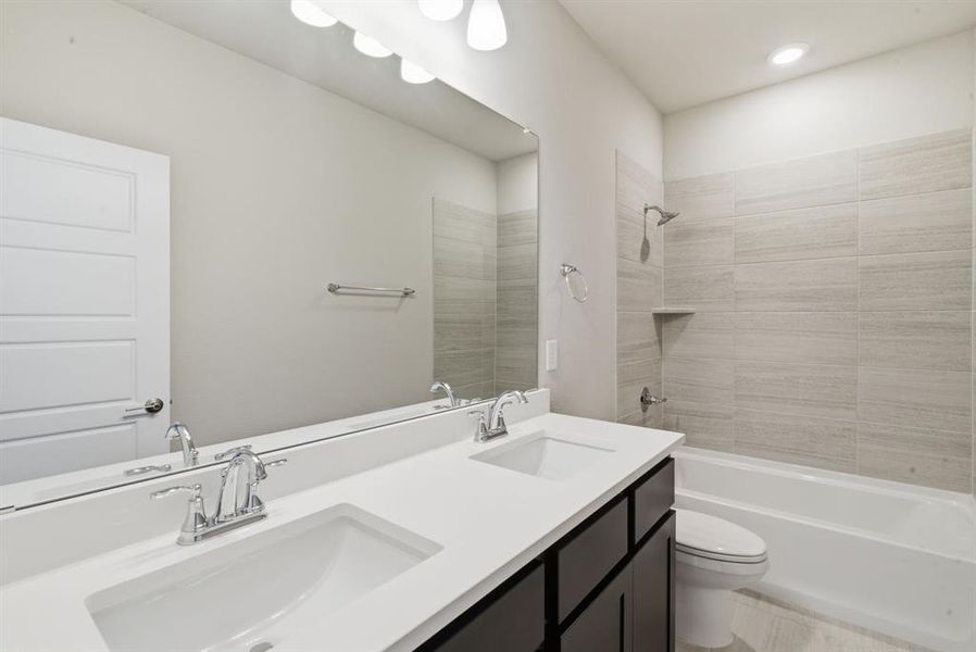 Full bath with double vanity and bathtub / shower combination