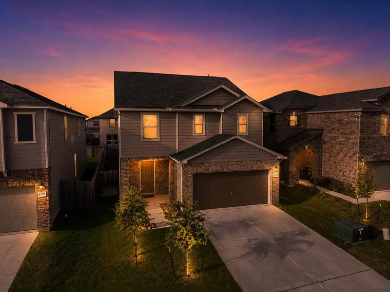 A welcoming front exterior with well-maintained landscaping under a vibrant sunset. A welcoming front exterior with well-maintained landscaping under a vibrant sunset.