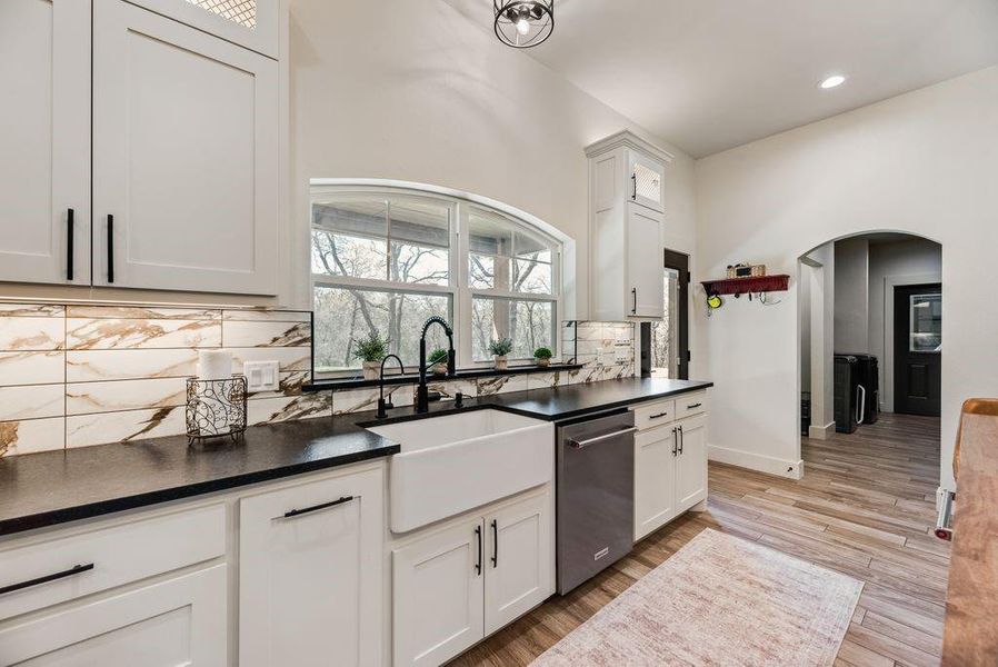Look at this Stunningly Beautiful Kitchen! Custom lighting throughout the cabinets, above, inset and under. Black Leathered Granite countertops, Quartz backsplash, butcher block island topper, pot filler, gas cook top and range and more!