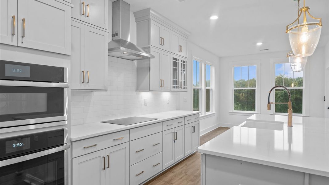 Highly skilled craftsmanship shines in this modern kitchen with pendant lighting and a central island focal point